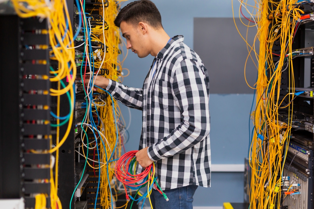 young network engineer with ethernet wires medium shot